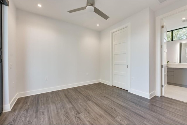 unfurnished bedroom featuring ceiling fan, connected bathroom, and dark hardwood / wood-style floors