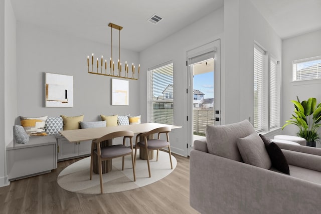 dining room with wood-type flooring, a notable chandelier, and breakfast area