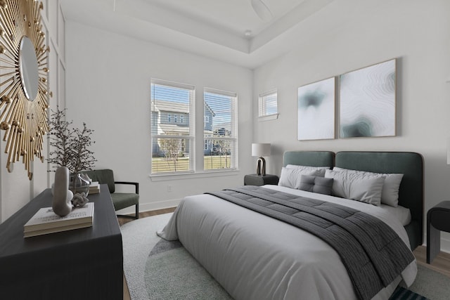 bedroom with wood-type flooring and a raised ceiling