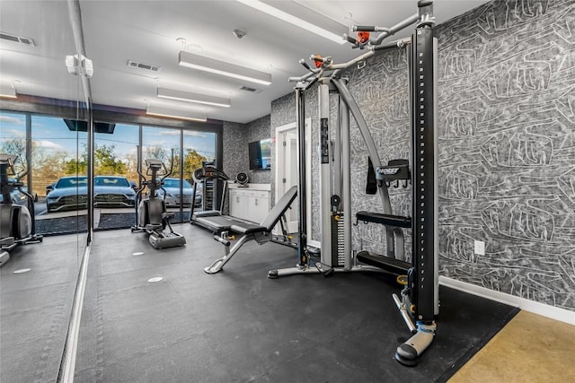 exercise room featuring visible vents, baseboards, and wallpapered walls