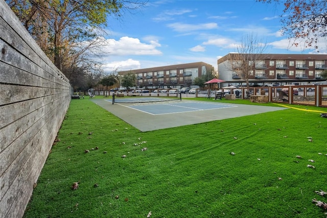 exterior space with tennis court and a lawn