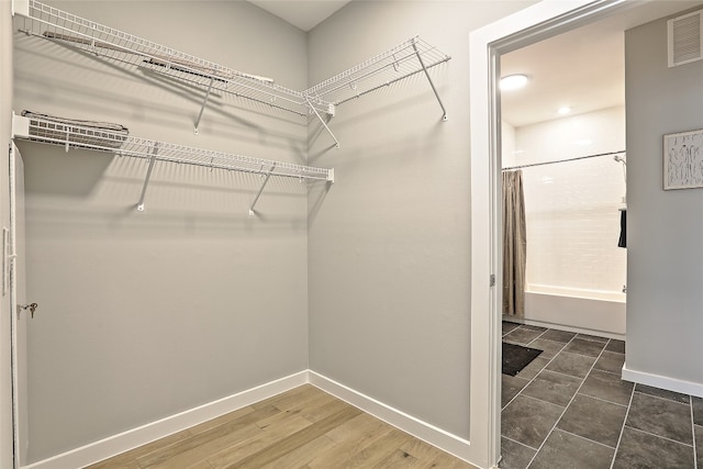 walk in closet with visible vents and wood finished floors