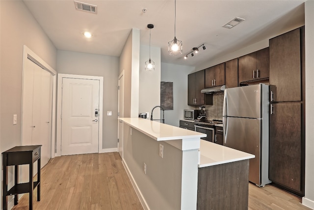 kitchen with dark brown cabinetry, visible vents, under cabinet range hood, and appliances with stainless steel finishes