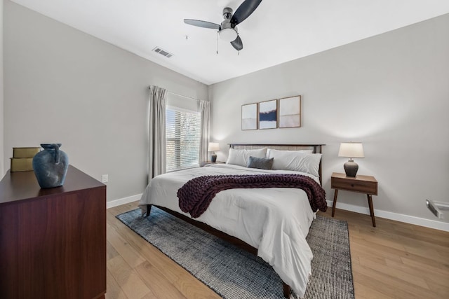 bedroom featuring visible vents, baseboards, light wood-style floors, and a ceiling fan