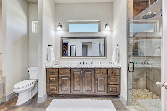 bathroom featuring an enclosed shower, vanity, and toilet