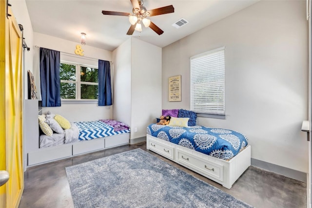 bedroom featuring ceiling fan and a barn door