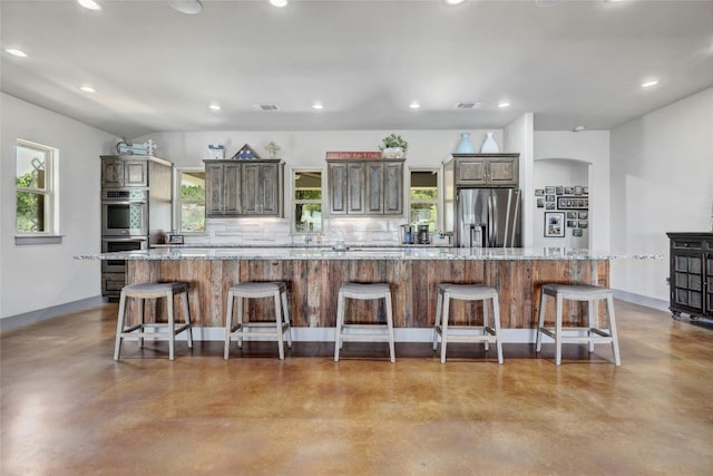 kitchen featuring appliances with stainless steel finishes, a breakfast bar, and a spacious island