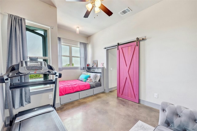 workout room with a barn door and ceiling fan