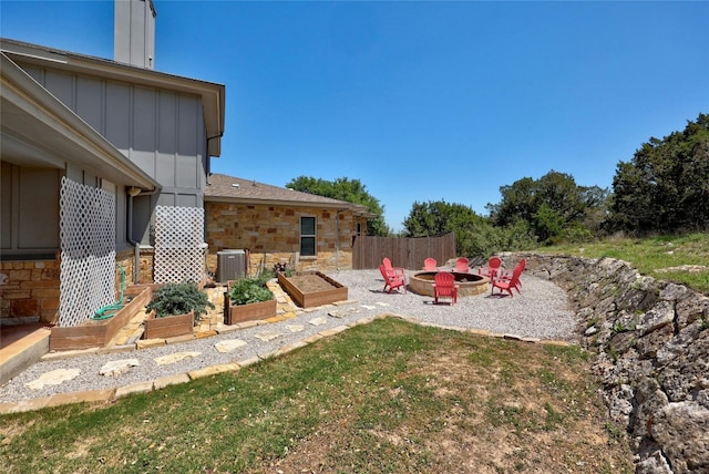 view of yard featuring central AC unit and an outdoor fire pit