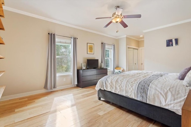 bedroom featuring multiple windows, crown molding, a closet, and light hardwood / wood-style flooring