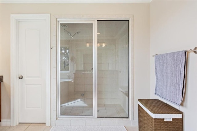 bathroom with a shower with shower door and tile patterned flooring