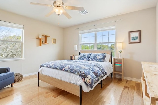 bedroom with multiple windows, ceiling fan, and light hardwood / wood-style flooring