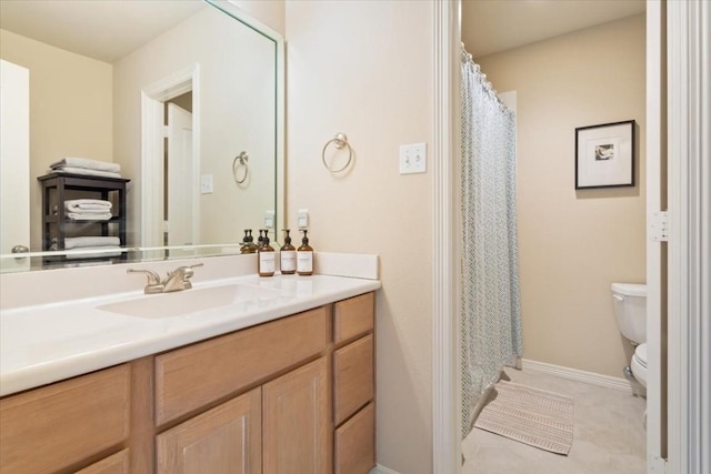 bathroom featuring tile patterned flooring, vanity, and toilet