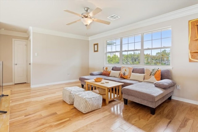 living room with ornamental molding, ceiling fan, and light wood-type flooring