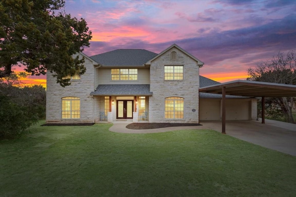 view of front of property with french doors, a yard, and a garage