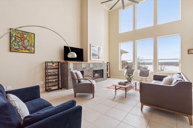 tiled living room featuring a towering ceiling and a fireplace