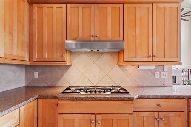 kitchen with stainless steel gas stovetop, tasteful backsplash, and stone counters