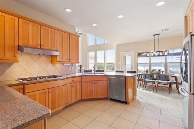 kitchen with sink, decorative light fixtures, light tile patterned floors, stainless steel appliances, and backsplash