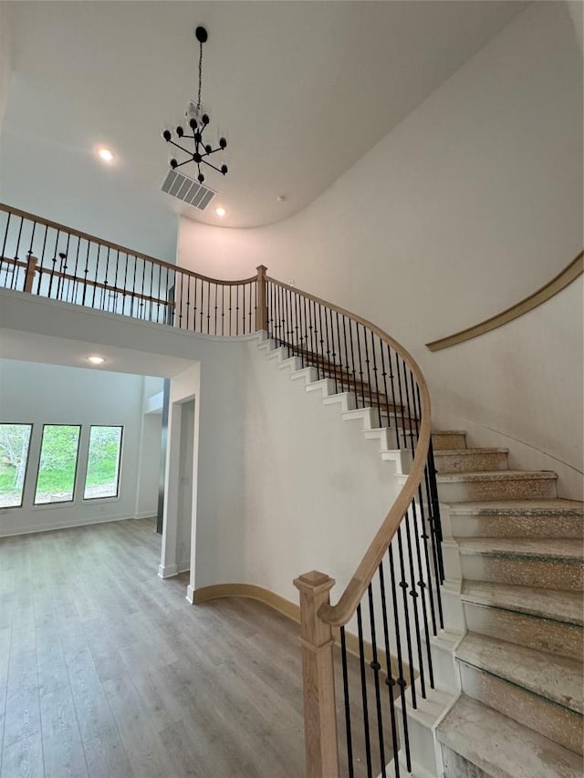 118 Bateleurfrey Cv, Cedar Creek, TX 78612 - stairs featuring wood finished floors, a high ceiling, baseboards, and recessed lighting