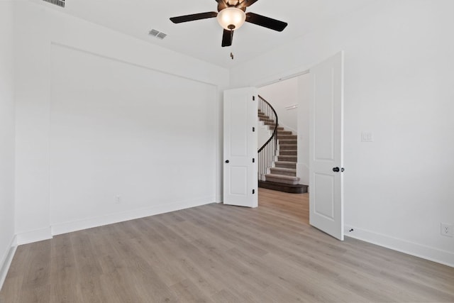 118 Bateleurfrey Cv, Cedar Creek, TX 78612 - empty room with ceiling fan, light wood finished floors, and stairway