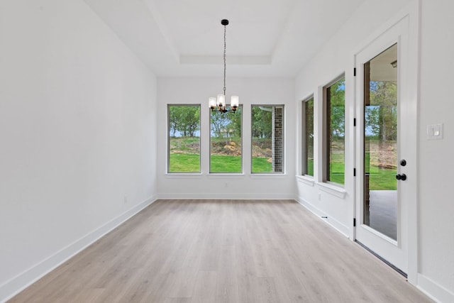118 Bateleurfrey Cv, Cedar Creek, TX 78612 - unfurnished dining area with light wood-type flooring, a chandelier, and a tray ceiling
