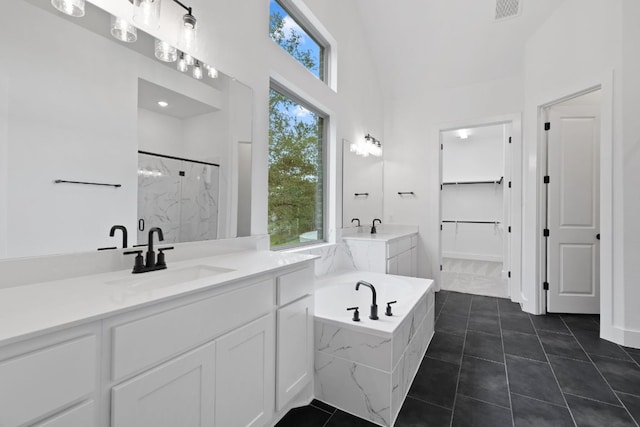 118 Bateleurfrey Cv, Cedar Creek, TX 78612 - full bathroom featuring a marble finish shower, a bath, vanity, a walk in closet, and a towering ceiling