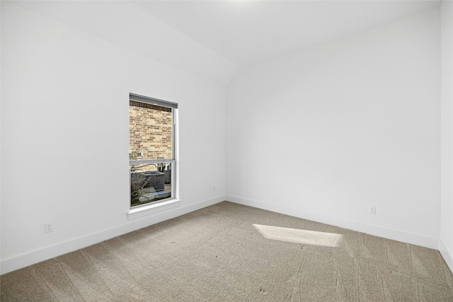 carpeted empty room featuring lofted ceiling