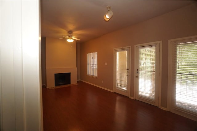 unfurnished living room featuring dark hardwood / wood-style floors and ceiling fan