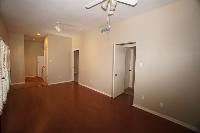 spare room with dark wood-type flooring and ceiling fan