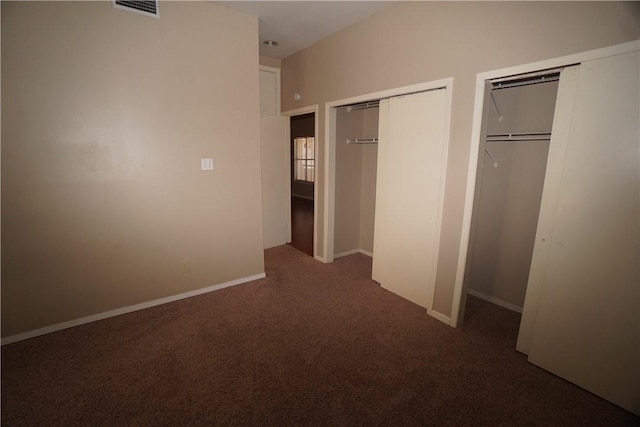 unfurnished bedroom featuring two closets and carpet floors