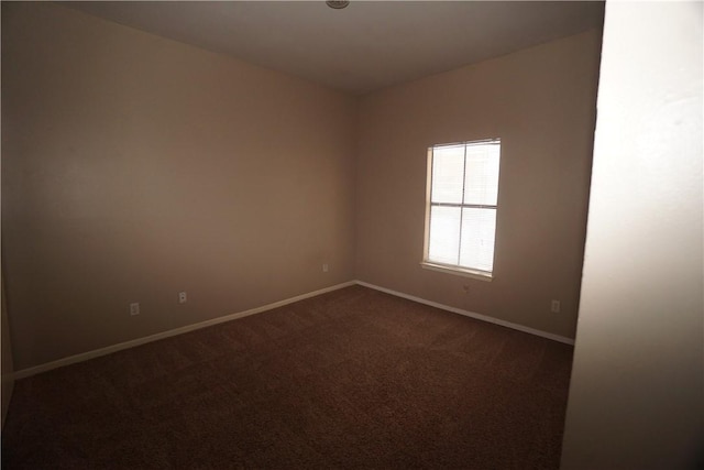 empty room featuring dark colored carpet