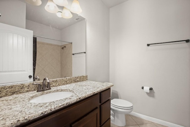 bathroom with tiled shower, vanity, tile patterned floors, toilet, and a chandelier