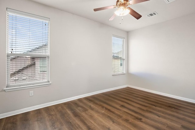 spare room with dark hardwood / wood-style flooring and ceiling fan