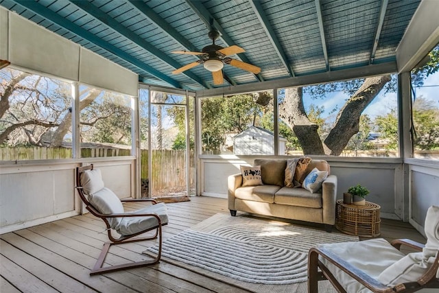 unfurnished sunroom with ceiling fan and vaulted ceiling with beams