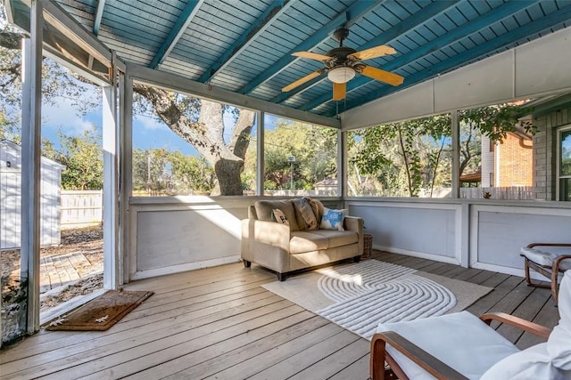 unfurnished sunroom featuring wood ceiling, ceiling fan, and vaulted ceiling with beams