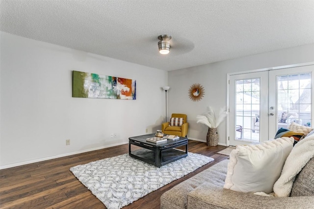 living room featuring ceiling fan, a textured ceiling, dark hardwood / wood-style flooring, and french doors