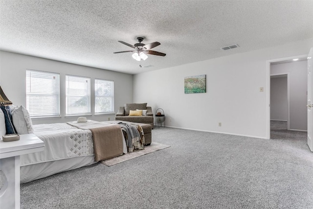 carpeted bedroom featuring ceiling fan and a textured ceiling