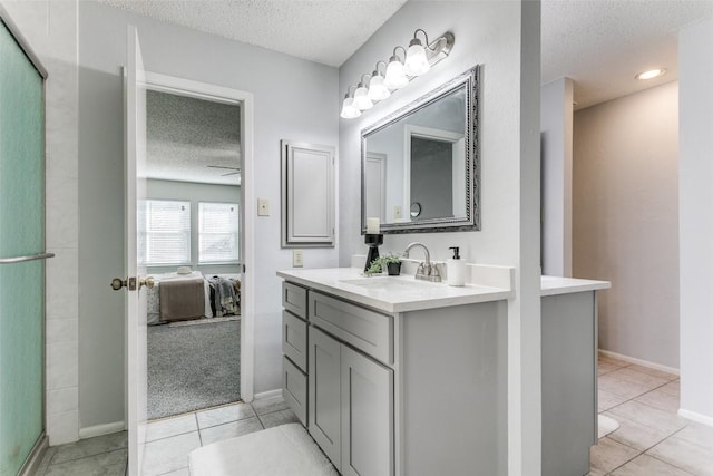 bathroom with tile patterned flooring, vanity, a textured ceiling, and a shower with shower door