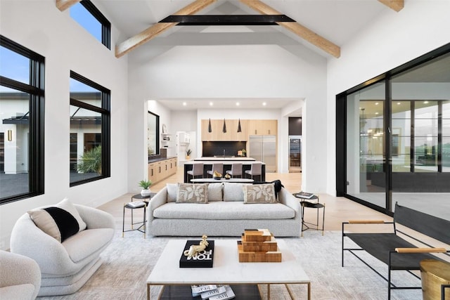 living room with light hardwood / wood-style flooring, high vaulted ceiling, and beamed ceiling