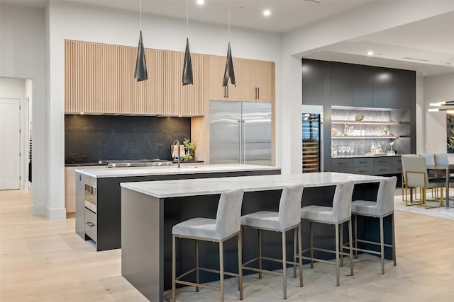 kitchen with light stone counters, decorative light fixtures, a breakfast bar, and a kitchen island