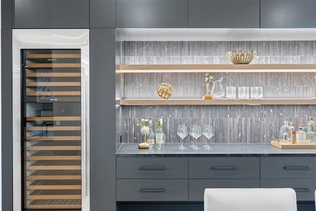 bar with gray cabinets and beverage cooler