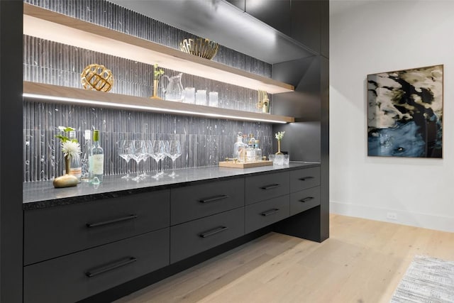 bar featuring decorative backsplash and light wood-type flooring