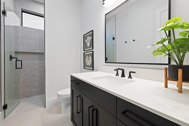 bathroom featuring vanity, a shower with door, and toilet