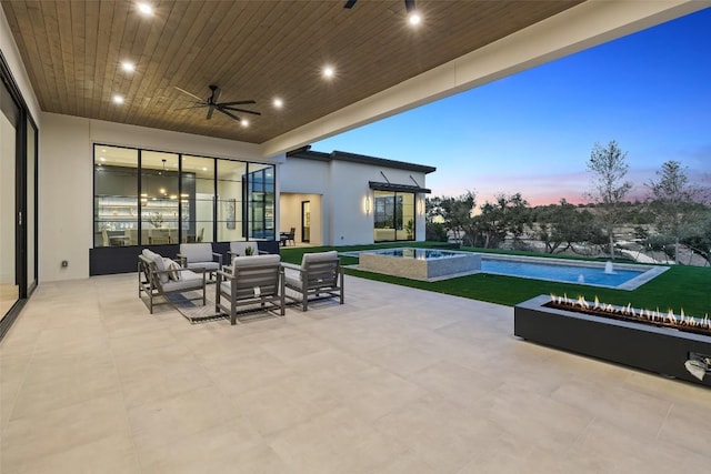 patio terrace at dusk featuring a swimming pool with hot tub, outdoor lounge area, and ceiling fan