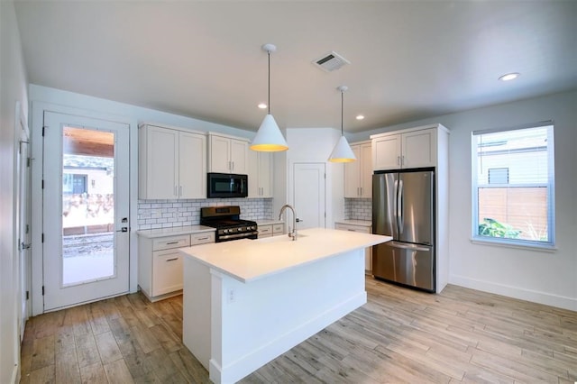 kitchen featuring white cabinetry, stainless steel appliances, decorative light fixtures, and backsplash