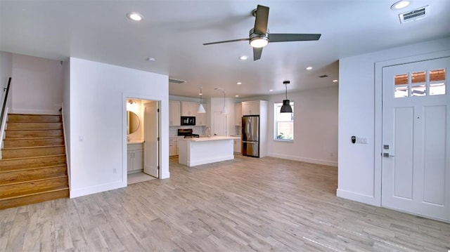 unfurnished living room featuring ceiling fan and light hardwood / wood-style flooring