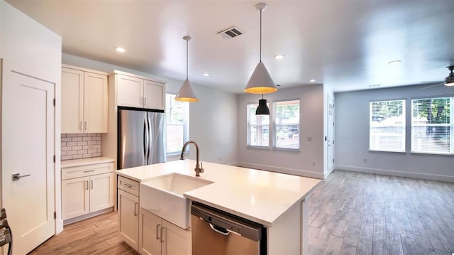 kitchen featuring sink, white cabinetry, hanging light fixtures, an island with sink, and stainless steel appliances