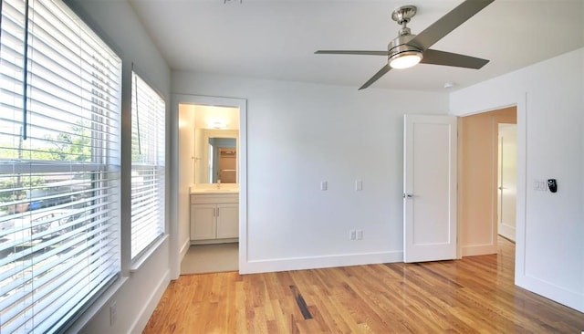 unfurnished bedroom with ceiling fan, connected bathroom, and light wood-type flooring