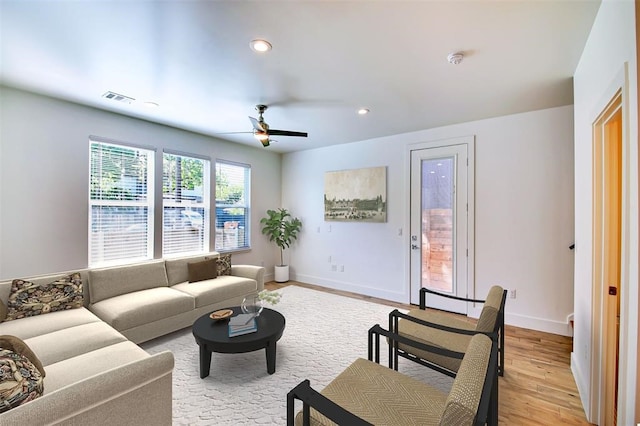 living room with ceiling fan and light hardwood / wood-style flooring