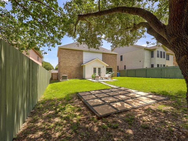 back of property with central AC, french doors, a patio, and a lawn